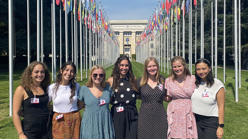 Undergraduate women studying peace at the University of Notre Dame pose as a group in front of the United Nations complex in Geneva, Switzerland.