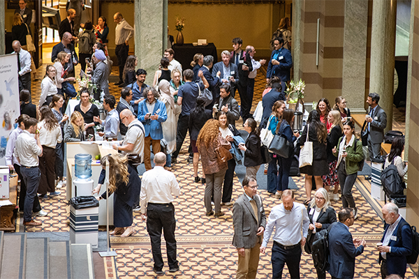 Attendees of the third annual AMC Conference gather in a foyer of the university during a break between sessions.